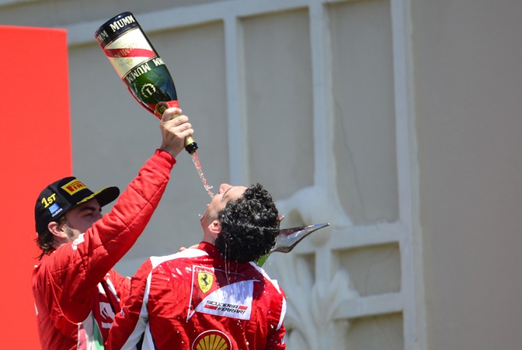 Alonso comemora no pódio com engenehiro da Ferrari Andrea Stella, no GP da Europa de 2012 (JAVIER SORIANOJavier Soriano/AFP)